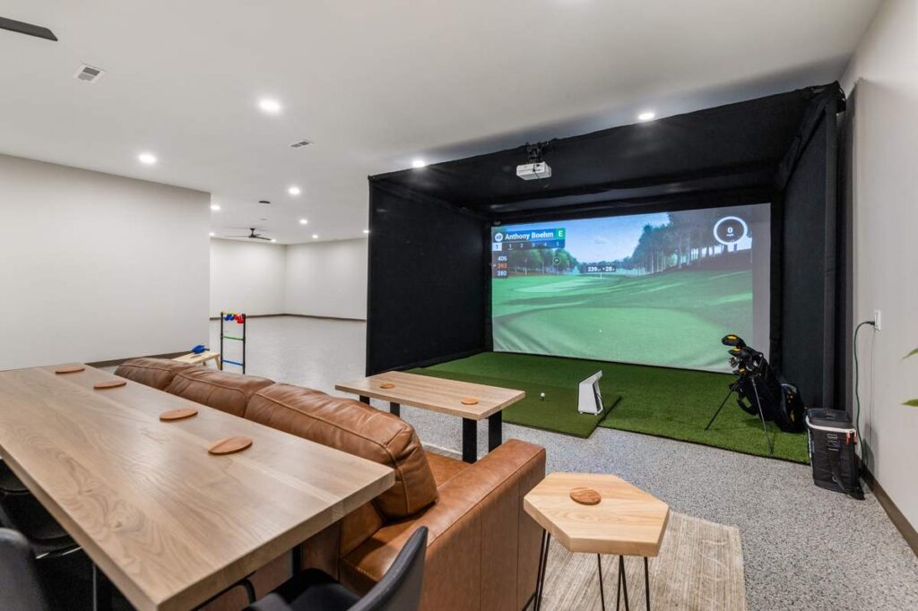 Entertainment space with golf simulator, seating area, and modern interior design